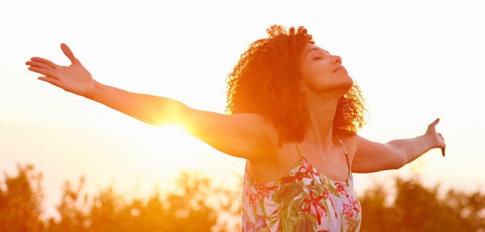 donna felice con sole alle spalle