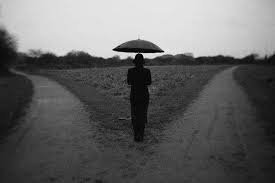 foto in bianco e nero rappresentante un uomo di fronte ad un bivio,