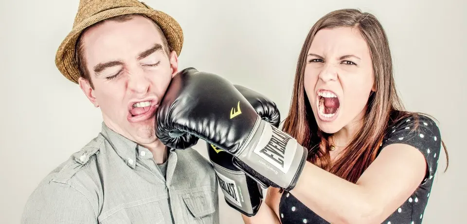 donna con guanti da puglie colpisce uomo al volto simbolo di persone aggressive